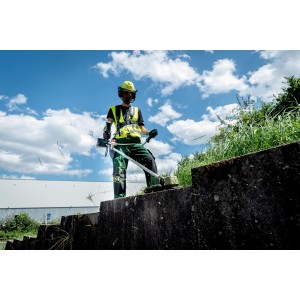 Homme utilisant une débroussailleuse à batterie Metabo FSB 36-18 LTX BL 40 pour couper l'herbe.
