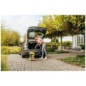 Femme aspirant le coffre d'une voiture avec l'aspirateur eau et poussière Kärcher WD 2 Plus S V-19/4/18/C.
