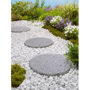 Pas japonais en pierre naturelle Sino Grey, Ø 25 cm, dans allée de jardin avec graviers décoratifs blancs.
