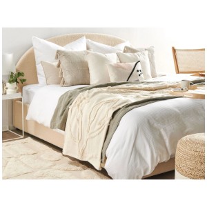 Coperta beige Beliani Acacia in cotone (130x160 cm) su un letto con cuscini.