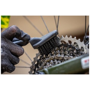 Muc-Off Reinigungsbürste Detailing Brush im Einsatz zur Reinigung einer Fahrradkette.
