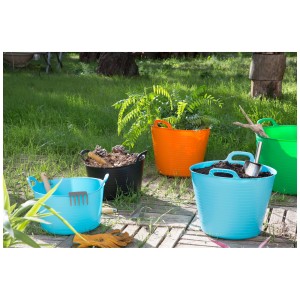Flexitubs multicolores (seaux en caoutchouc) dans un jardin, aides de jardinage polyvalentes.
