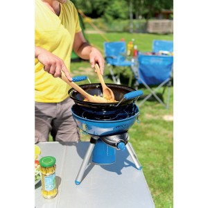 Grill a gas blu Party Grill 400 CV con wok e persona che cucina all'aperto.