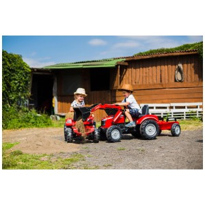 Trattore rosso Falk Massey Ferguson con rimorchio, giocato da due bambini all'aperto.