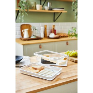 Due contenitori frigo Rotho Cauma bianchi con cibo su un piano cucina.