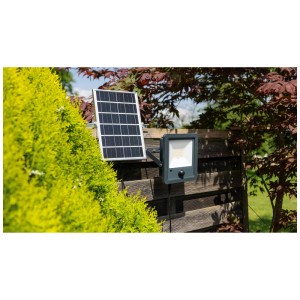 Projecteur LED solaire gris Steffen Worklight 50W avec panneau solaire et détecteur de mouvement sur mur en bois.