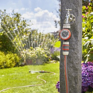 Timer per irrigazione Gardena su rubinetto con irrigatore in giardino.