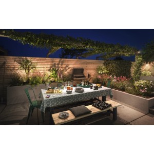 Gedeckter Gartentisch mit Philips Hue Außenbeleuchtung im Hintergrund.