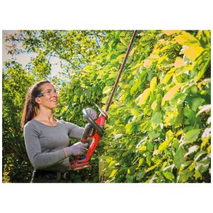 Femme taillant une haie avec la cisaille à haie sans fil rouge Einhell GP-CH 18/50 Li BL-Solo.