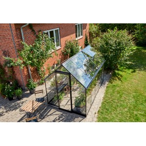 Serre Halls Qube 610, 6,4 m², noire, avec fenêtre de toit ouverte dans le jardin.