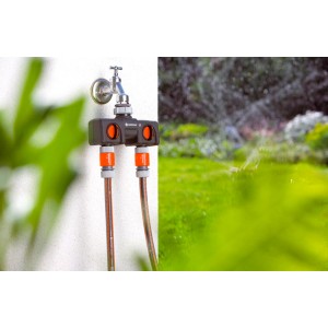 Distributore a 2 vie Gardena su rubinetto con due tubi da giardino collegati.