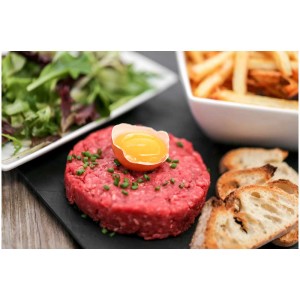 Frisch zubereitetes Beef Tatar mit Eigelb, Salat, Pommes und Brot. Zubereitet mit dem Trisa Fleischwolf.