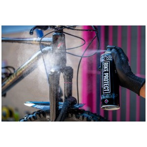 Muc-Off Bike Protect Spray wird auf ein Fahrrad gesprüht. Teil des 8-tlg. Reinigungssets.