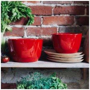 Ciotole da insalata rosse Emile Henry in ceramica, 5,5 l, su una mensola con erbe aromatiche e piatti.
