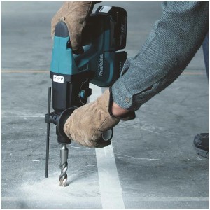 Marteau perforateur sans fil Makita DHR243ZJ en action perçant du béton.