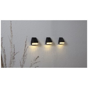 Tre applique solari nere Star Trading Wandy Mini su una parete. Design a lanterna con luce bianca calda.