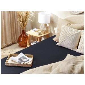 Drap-housse noir Janbu en coton, 90x200 cm, sur un lit décoré.