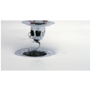 Tappo lavabo cromato Drain Magic con filtro, pieno di capelli, estratto da un lavello bianco. Previene intasamenti.