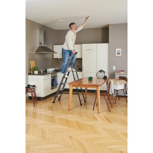 Uomo su scala che utilizza il laser a linee incrociate Bosch UniversalLevel 2 per lavori al soffitto.