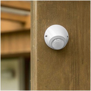 Rilevatore di movimento Steffen IP65 bianco con rilevamento a 360° su parete in legno.
