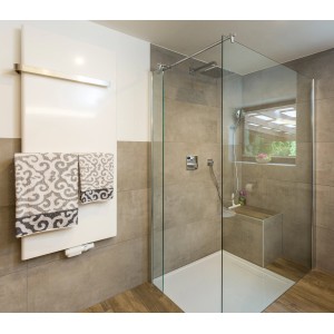 Bagno moderno con doccia a filo pavimento, termosifone portasciugamani e piastrelle grigie.