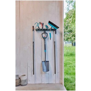 Barra porta attrezzi Gardena Flex con attrezzi da giardino come vanga, scopa e doccia a parete.