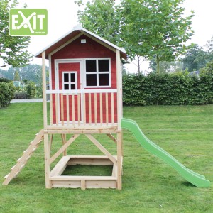 Maisonnette en bois rouge EXIT Loft 500 avec toboggan, bac à sable et échelle dans le jardin.