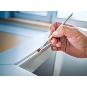 Mano che dipinge con pennello per smalto LUX. Set di pennelli ideale per ritocchi.