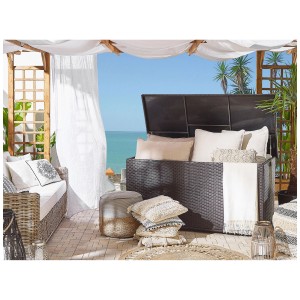 Coffre de rangement pour coussins en rotin marron Modena (80x155x75cm) avec couvercle ouvert, rempli de coussins et couvertures.