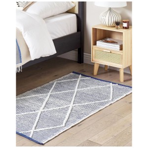 Tapis en coton bleu Beliani Synopa (80x150 cm) avec motif losanges dans une chambre.