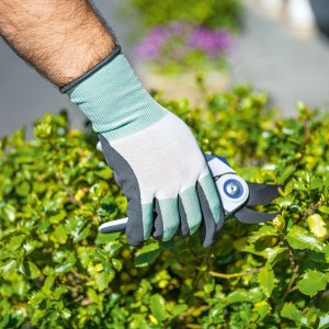 Mano con guanto da lavoro LUX Active Cool taglia 10 che taglia una siepe.