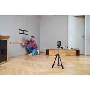 Un homme utilise le laser lignes croisées Bosch UniversalLevel 2 pour l'alignement sur un mur.