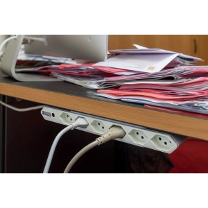 Multiprise Steba IQ, 6 prises, blanc, 1,5 m, avec fixation par clip sous un bureau.