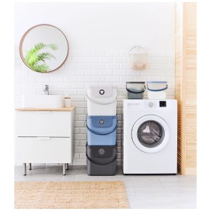 Paniers à linge Rotho Albula empilés en blanc, bleu et gris dans la salle de bain.