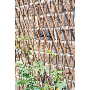 Grigliato in salice 170x15cm su muro di mattoni con piante verdi.