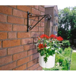 Crochet mural noir pour suspensions (30 cm) avec panier suspendu blanc et fleurs rouges sur mur de briques.