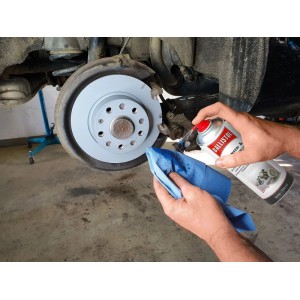 Mains pulvérisent Ballistol nettoyant freins et pièces sur un disque. Nettoie et dégraisse efficacement freins et pièces auto.