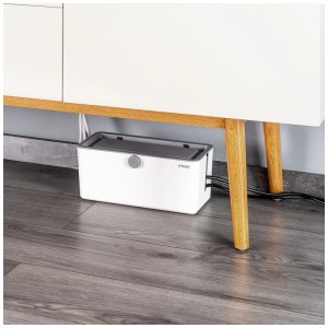 Reer Kabelbox CableGuard aus Kunststoff unter einem Möbelstück. Kindersichere Aufbewahrung für Kabel und Steckdosenleisten.