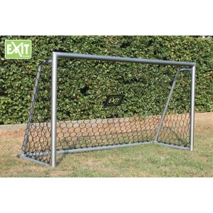 Porta da calcio EXIT Scala in alluminio (220x120cm) con rete nera davanti a siepe verde.