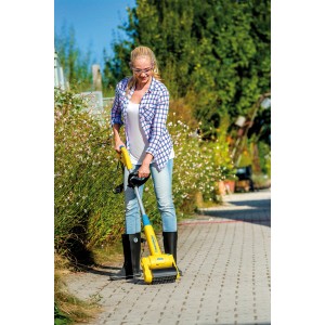 Femme utilisant Gloria Steinbürste Medium pour nettoyer les pavés.