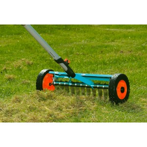 Scarificateur Gardena combisystem avec largeur de travail de 32 cm utilisé sur une pelouse.