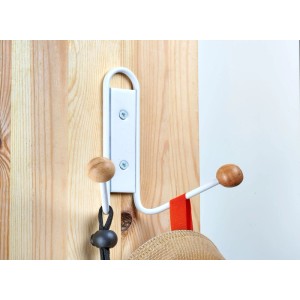 Hettich Doppelhaken Typ 84 aus weissem Metall mit zwei hellen Holzknöpfen, an Holzwand montiert. Ideal für Garderobenleisten.