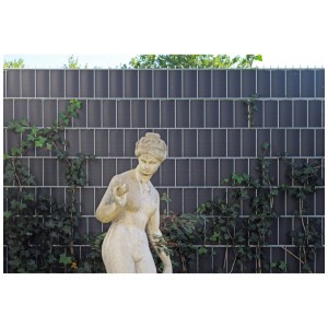 Strisce frangivista in plastica antracite nella recinzione, combinate con una statua e edera.