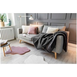 Coperta Coste antracite (130x180 cm) su divano grigio con cuscini in soggiorno.