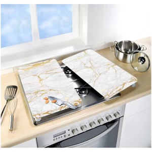 Set di 2 coperture per piano cottura in vetro Wenko marmo oro (30x52cm) su una stufa.