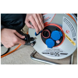 Enrouleur orange Brennenstuhl Garant SK 290 FI+BT avec câble de 50 m et prises suisses en utilisation.