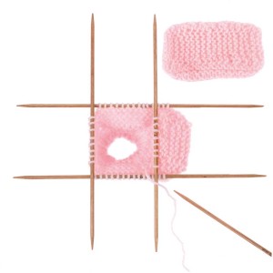 Laine bébé rose (50g) avec aiguilles à tricoter et motif.