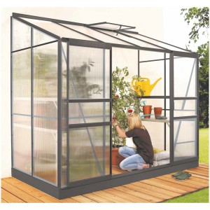 Serra addossata nera Vitavia Ida 3300 con doppia porta scorrevole e donna che fa giardinaggio.