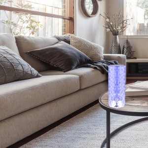 Lampada da tavolo a batteria Brilo con effetto cristallo e illuminazione RGB su un tavolo in soggiorno.