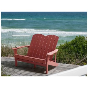 Banc de jardin Adirondack 2 places rouge Beliani en bois synthétique aspect bois sur ponton en bord de mer.